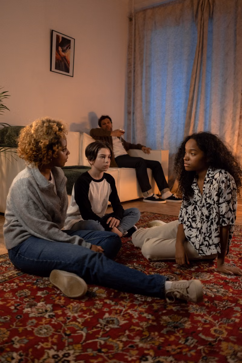 A diverse family engaged in a serious discussion in their cozy living room.
